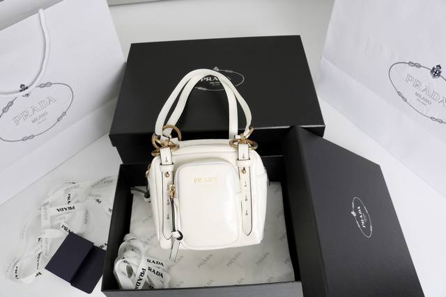 独家背景实拍 简介：新款方正手提包甄选复古感柔软牛皮革制成。复古金属五金配件与典藏元素拉链口袋，彰显复古魅力。 型号1Bb137白 材质采用专柜质感进口亮面皮革