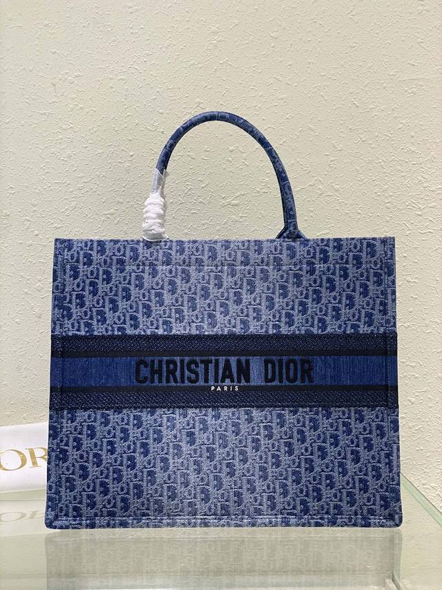 这款 Dior Book Tote 手袋由 Dior 女装创意总监玛丽亚 嘉茜娅 蔻丽 Maria Grazia Chiuri 设计，是体现 Dior 美学的主