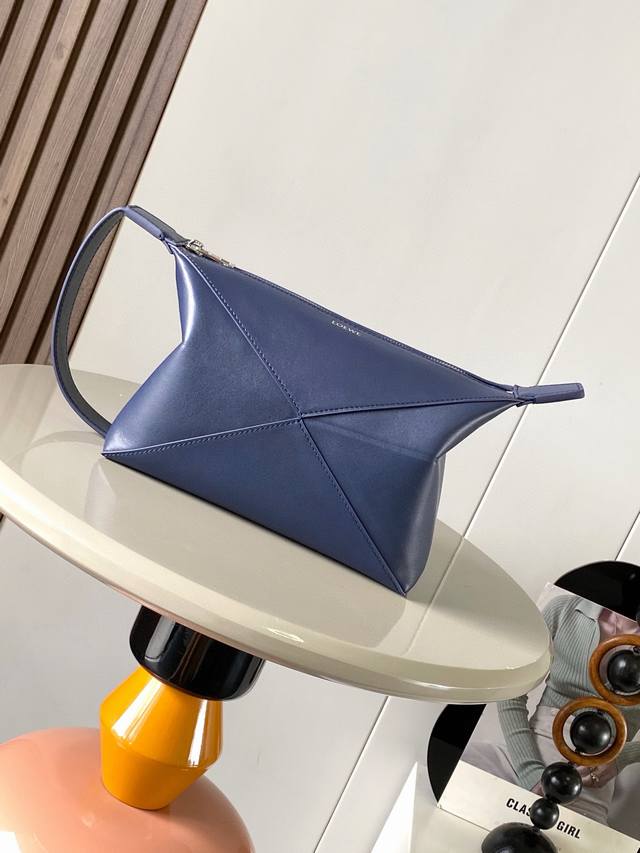 新款亮面牛皮革 Puzzle Fold 亮面牛皮革洗漱包从 Puzzle Fold 手袋的几何线条汲取灵感以富含几何建筑美感的镶片重新诠释可手提或悬挂于手腕＊拉