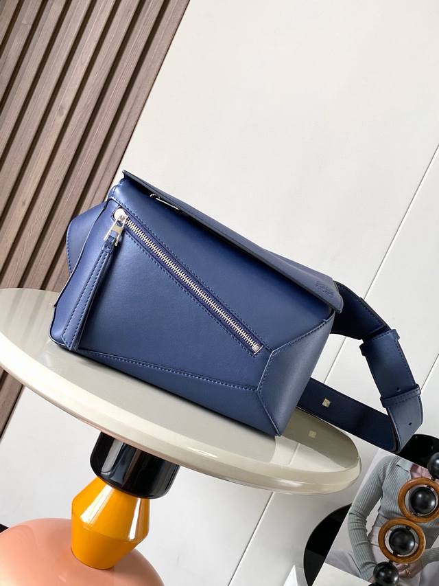 新款小号经典牛皮革 Puzzle 腰包长方体形状和精确的切割技术创造了Puzzle 独特的几何线条这款小号腰包采用经典牛皮革制成皮质柔软轻便，造型低调有辨识度不