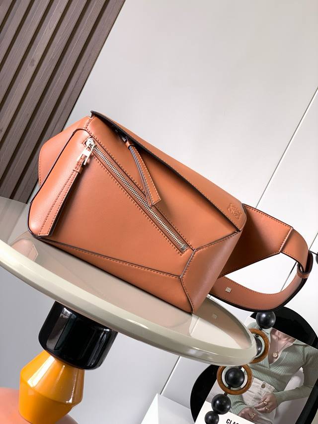 新款小号经典牛皮革 Puzzle 腰包长方体形状和精确的切割技术创造了Puzzle 独特的几何线条这款小号腰包采用经典牛皮革制成皮质柔软轻便，造型低调有辨识度不