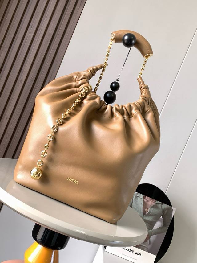 明星同款 中号纳帕羊皮革Squeeze手袋是款精致而柔美的全新手袋全新发布的 Squeeze 手袋采用柔软丝滑的Mellow纳帕小羊皮制作而成无衬里结构有效减轻