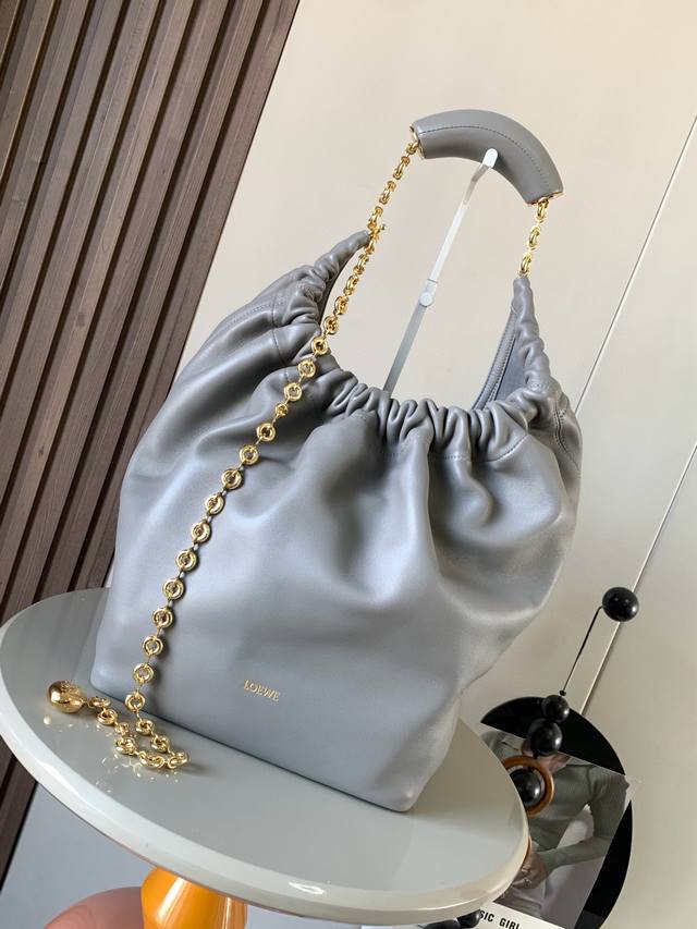 明星同款 中号纳帕羊皮革Squeeze手袋是款精致而柔美的全新手袋全新发布的 Squeeze 手袋采用柔软丝滑的Mellow纳帕小羊皮制作而成无衬里结构有效减轻