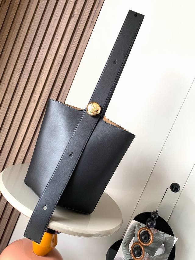 中号柔软牛皮革 Pebble Bucket 水桶包是L0Ewe极简主义的又一代表水桶包时尚简约且能装Anagram金色鹅卵石配件是点睛之笔这个包的一个特点是肩带