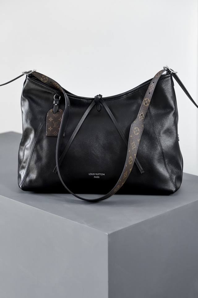 M25143 Carryall Dark 中号手袋 本款 Carryall Dark 中号手袋以柔软羊皮革塑造时尚慵懒廓形，为 春夏秀场造型增添瞩目姿彩。抛光金