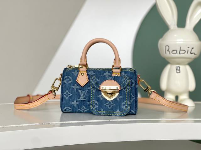 海原外单 独实家拍 M82950 可爱的Speedy Nano手袋更可爱的石洗花押字牛仔与天然皮革处理和可拆卸肩带。牛仔帆布是由认证的有机棉制成的。在包的侧面是