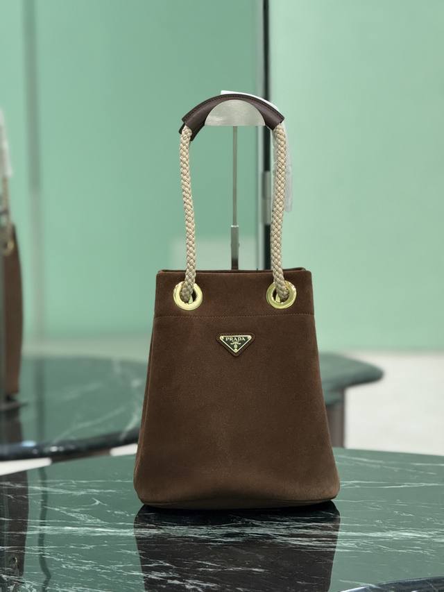 正品级 新款水桶包 这款Re-Nylon 手袋的設計采用进口麂皮面料和小牛皮。獨特的組合添上迷人點綴。滑動式繩索手挽凸顯這款手袋的靈活百搭，方便手提或肩背 斜跨