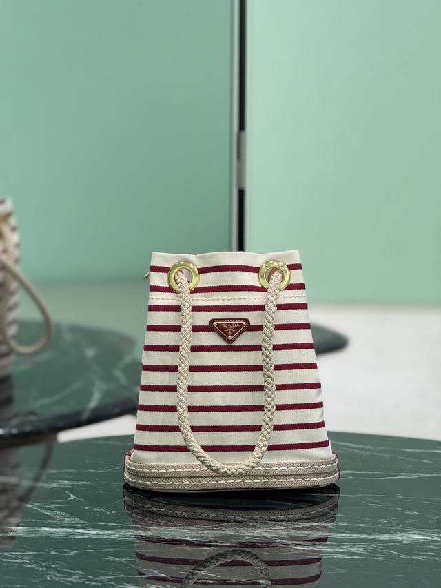 新款水桶包 这款织物水桶包饰以航海风条纹图案,为造型增添色彩。底部的设计灵感源自草编鞋,绳索则是象征着航海世界的另一细节元素,共同营造出浓郁的夏日风情。顶级五金 新款水桶包 这款织物水桶包饰以航海风条纹图案,为造型增添色彩。底部的设计灵感源自草编鞋,绳索则是象征着航海世界的另一细节元素,共同营造出浓郁的夏日风情。顶级五金