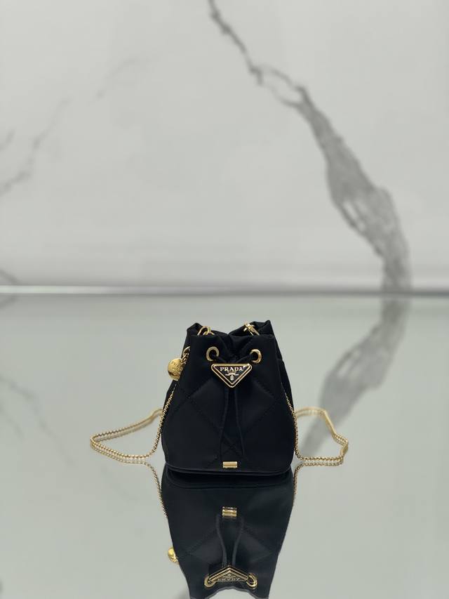 绣格小水桶 这款绣格小水桶采用复杂绣格手工和进口尼龙面料，涂珐琅金属三角形徽标装饰开合设计。金属铁琏可斜跨。太可爱了，上身的效果非常吸眼，可仙可酷，难道你不心动