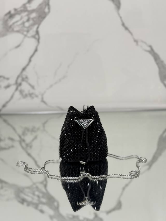 水晶Mini小水桶 这款Mini小水桶采用进口仿水晶和缎面材料组合，涂珐琅金属三角形徽标装饰开合设计。金属铁琏可斜跨。太可爱了 Bling Bling的效果非常