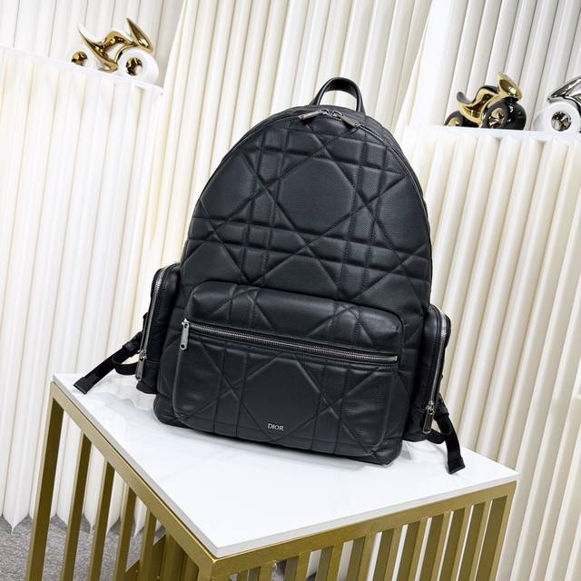 市场最高版本 原单品质 正品打版 这款双肩背包是二零二四冬季男装系列新品，将现代风格与高订精神融为一体，醒目时尚。采用黑色牛皮革等材质精心制作，饰以加大藤格纹图