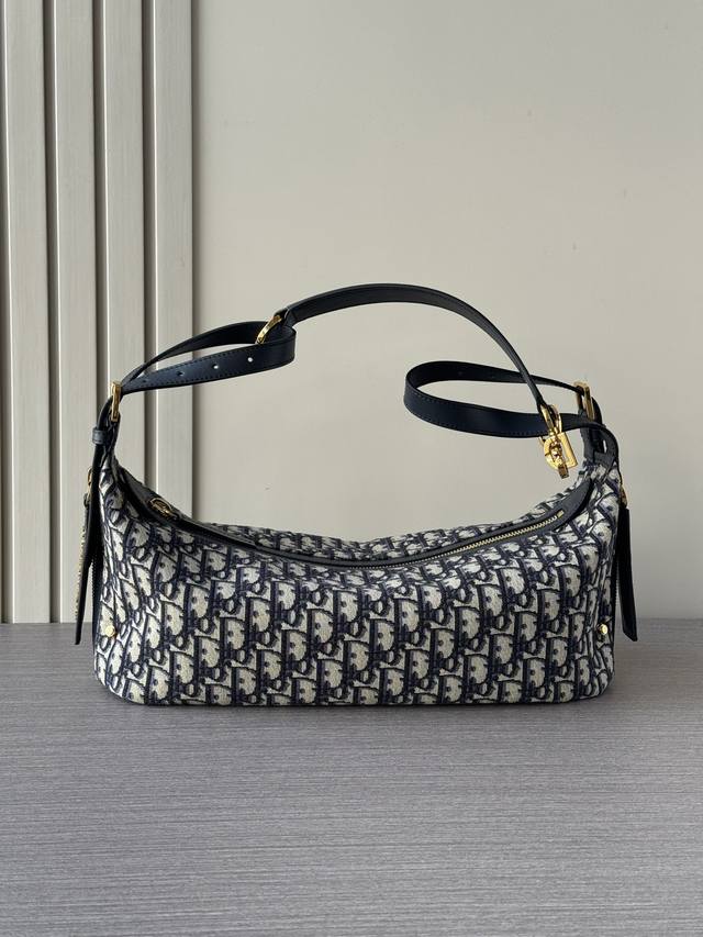 顶级对版原厂皮这款 D-Journey 手袋质地柔软，以摩登设计全新演绎水饺包廓形。采用蓝色 Oblique 印花面料等材质精心制作，主隔层内设有一个拉链口袋，