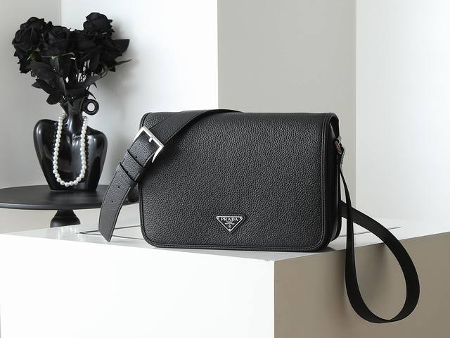 新款邮差包2Vd075 这款精致多功能的单肩包采用流畅设计，由柔软牛皮革制成，具有自然触感的表面。流畅的细节强调了简单的轮廓，可调节皮革肩带，磁扣翻盖设计，上身