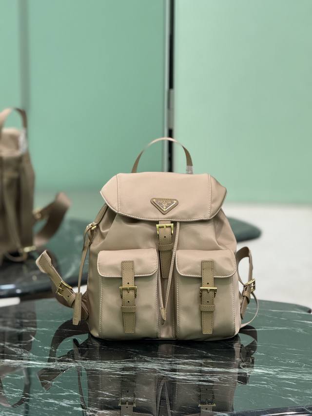 降落伞尼龙背包 P家最经典最畅销最百搭的背包，轻便防雨容量适中，出行随性搭配 进口降落伞布料-防水防晒 正面三角搪瓷徽标十字纹牛皮饰边 抽绳内袋+前面两个拉链外