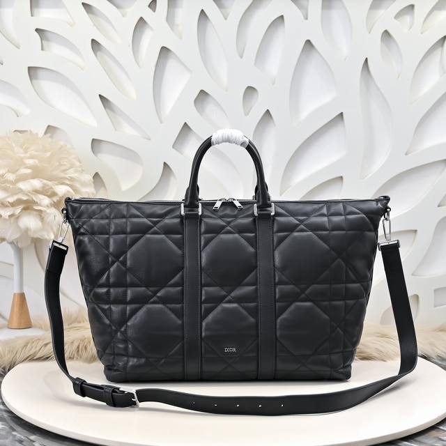 Dior-迪奥专柜最新款手提包 旅行包官网同步 这款Weekender手袋彰显经久不衰的高雅风格 采用黑色牛皮革精心制作 饰以加大藤格纹图案 正面Dior标志提 Dior-迪奥专柜最新款手提包 旅行包官网同步 这款Weekender手袋彰显经久不衰的高雅风格 采用黑色牛皮革精心制作 饰以加大藤格纹图案 正面Dior标志提