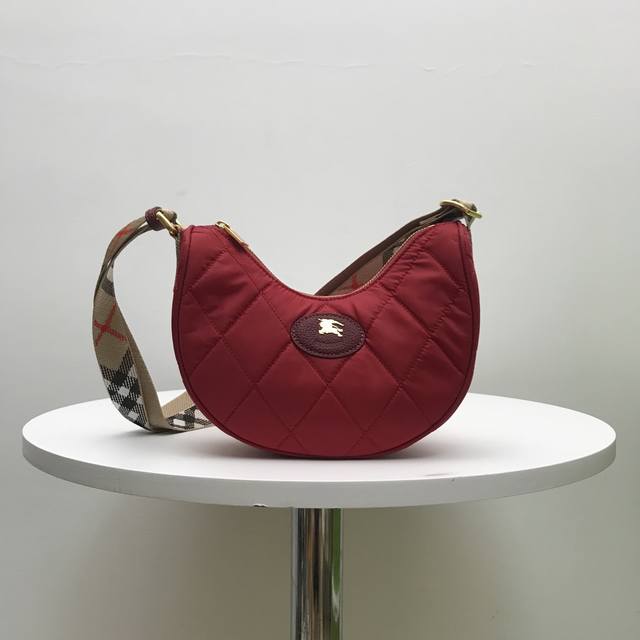 B家顶级原单 斜背包，汲取英伦乡间雅致灵感。选用绗缝尼龙混纺面料打造，装饰新季色调精纺 Bur 格纹。融入同色系皮革饰边和骑士印章，源自 1980 年代品牌包款