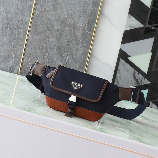 新款腰包2Vh176 这款百搭时尚单肩包采用鹿皮细节配小牛皮+进口尼龙材质。小巧款型点缀皮革饰边，侧面插扣等细节精致而实用，可调节肩带便于斜挎。涂珐琅三角形金属