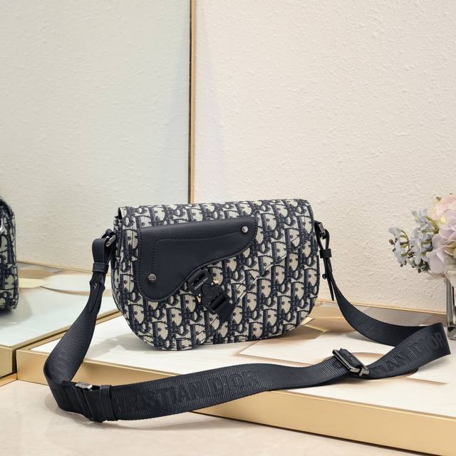 迪奥Dior单肩马鞍信使包 杏布]型号 1030 这款马鞍信使包是二零二四秋季男装系列新品，精巧时尚。采用黑色 Oblique 印花面料精心制作，正面饰以一个贴