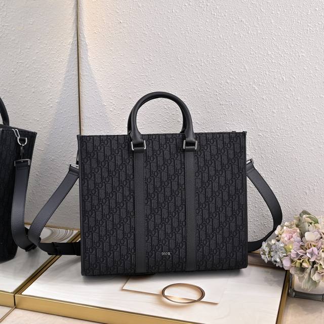 黑色 Oblique 面料 这款East-West 手袋彰显经久不衰的高雅风格。采用黑色Oblique印花面料精心制作，全新演绎经典的Dior图案，饰以同色调粒