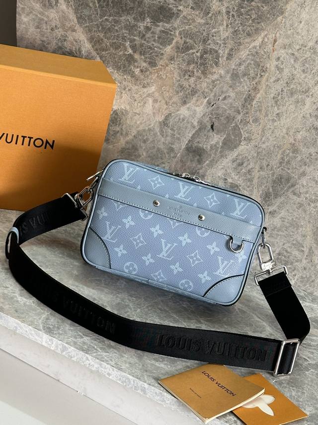 型号：M14073浅蓝 本款 Alpha 邮差包为 Taga 牛皮革和 Monogram 涂层帆布渲染明亮色调，以精巧设计为都市出行再添摩登之选。方正构型、加固