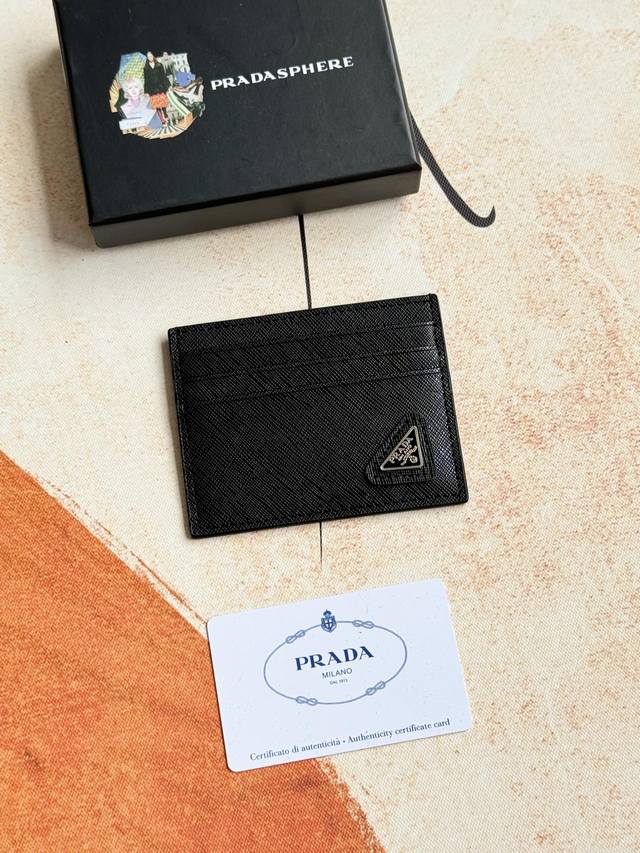 Prada经典款女士卡片夹专柜官网同步，型号1Mc025斜三角麦 走线做工精湛完美 十字纹牛皮，这款Saffiano皮革卡片夹以标志性的涂珐琅金属贴花装饰，开启