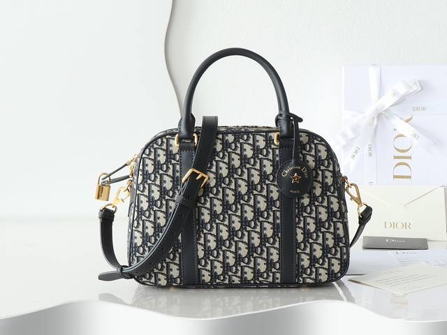 D-Vibe 保龄球包大号 蓝D布配皮 休闲运动风来袭，款式简约又时尚，采用蓝色 Obliaue 印花面料精心制作，别具一格的皮革钥匙包，字母标志并点缀金属星星