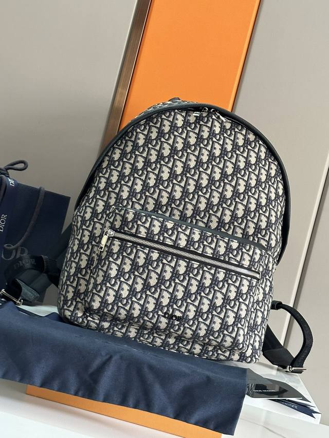 大号黑字唛下 顶级原单 这款 Rider 双肩背包轮廓简约，经典的学院款式洋溢着活力。时尚现代，采用米色和黑色提花面料精心制作，饰以 Oblique 印花。延续