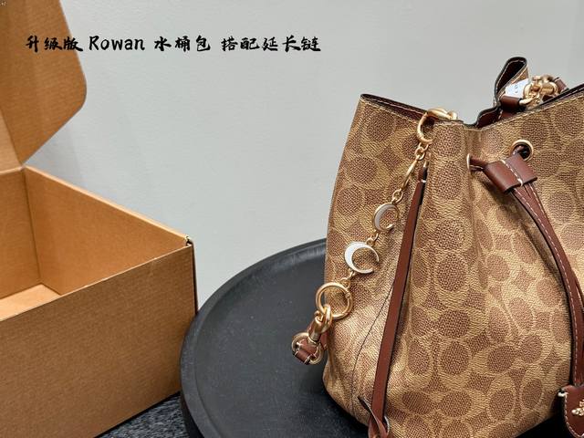 礼盒包装 搭配延长链条 挂件！ 蔻驰Coach Rowan 水桶包 作为一款出色的全能单肩包，尺寸不会太大或太小，可妥善收纳日常所需物品。 采用拋光鹅软石纹皮革
