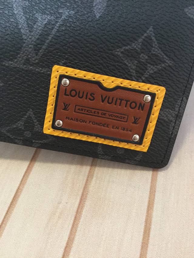 M69253 黑花短款钱包 ： Multiple 钱夹属于 Gaston Labels 限量版系列，由 Monogram Eclipse 涂层帆布制成，饰有的压