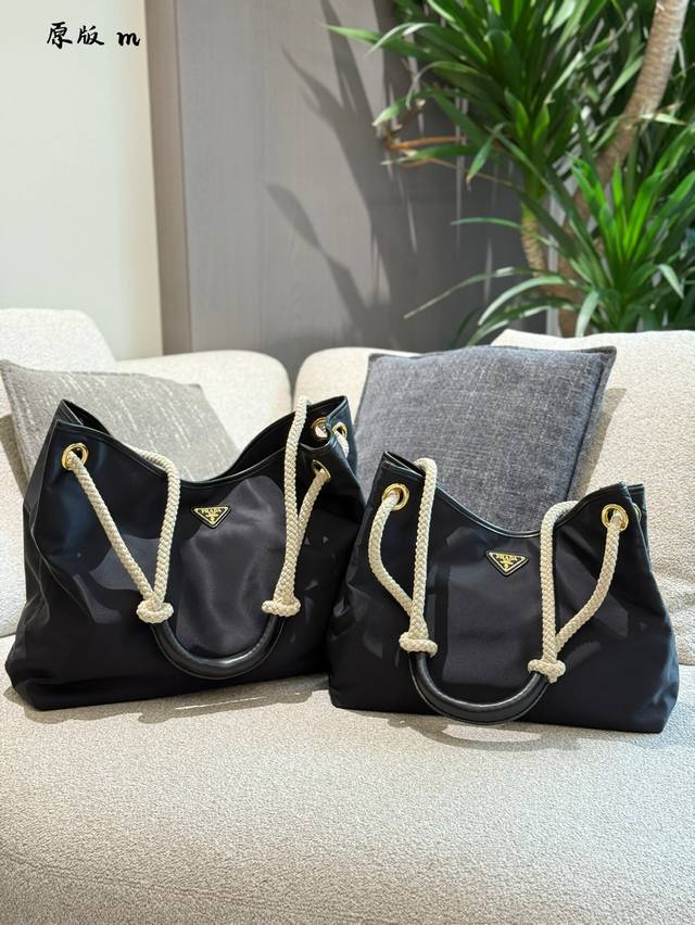 Prada托特包大购物袋 这款再生尼龙包袋灵感源自海洋风格的经典元素，采用新颖精美搭配，彰显活泼个性风格。滑动编绳手提柄为这款多功能配饰勾勒Oversize廓形