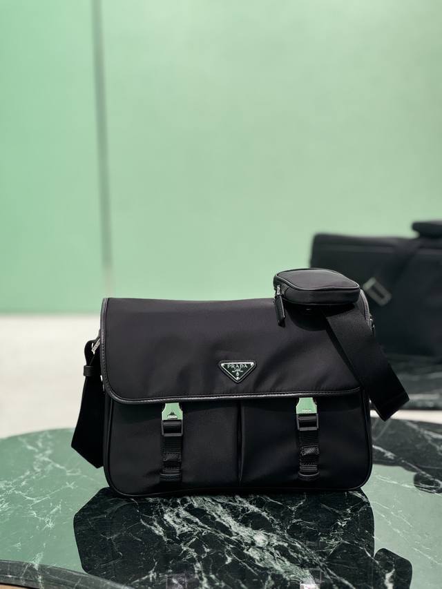 升级版 翻盖单肩包 大号 这款尼龙翻盖手袋饰有经典的Saffiano皮革饰边，配有两枚旁开扣，并饰有标志性的三角形金属徽标，彰显时尚设计格调，采用进口尼龙和Sa