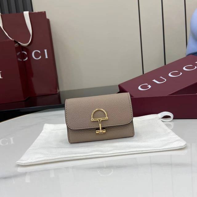 配全套原厂专柜包装 新品 Gucci延续品牌深厚传承，深化与马术本源的联结。半马衔扣图案化身为开合细节，为多款小皮件增色添彩。这款卡片夹以灰粉色粒面牛皮革匠心打