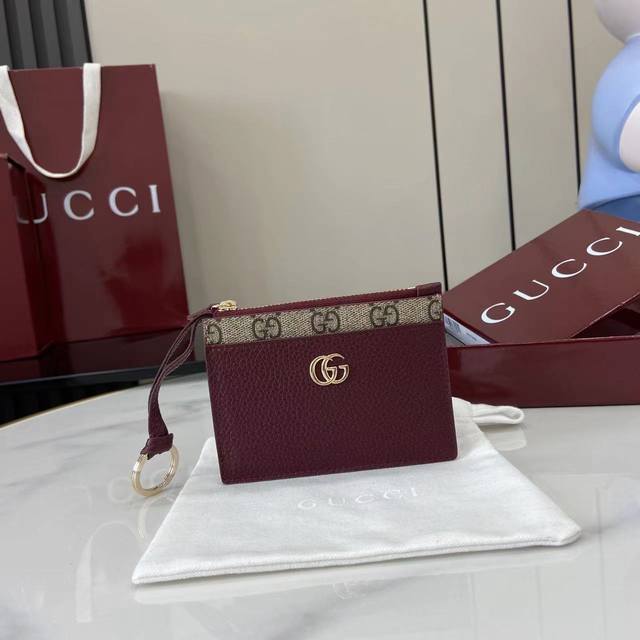配全套原厂专柜包装 新品 Gg Marmont系列全新推出多款色彩斑斓的匠心之作，新增的功能性设计为经典轮廓注入灵动活力。这款卡片夹以古驰安可拉红和啡Pvc呈现
