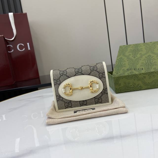 配全套原厂绿盒包装 在 早秋系列中，全新推出这款由Gg Supreme帆布和白色皮革材质制成的Gucci Horsebit 1955系列卡包。该系列采用与手袋一