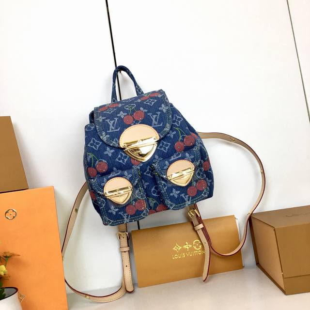 M 13679，本款 Venice 双肩包取材涂层帆布，以日本艺术家村上隆笔下的鲜明色调描绘 Monogram 图案，彰显路易威登 X 村上隆再版系列的灵动意趣