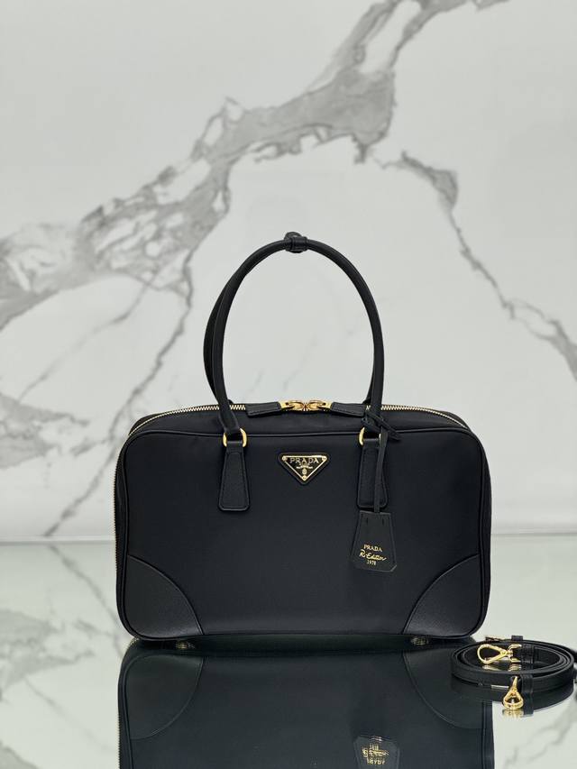 双提手手袋 大号 这款选用再生尼龙打造,融入特有的风格元素,搭配精致的Saffiano皮革细节,彻底颠覆人们对奢侈品传统的认知。在实用的设计点缀和精致的细节之间 双提手手袋 大号 这款选用再生尼龙打造,融入特有的风格元素,搭配精致的Saffiano皮革细节,彻底颠覆人们对奢侈品传统的认知。在实用的设计点缀和精致的细节之间