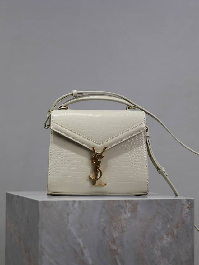 白色金扣 鳄鱼纹Cassandra Mini手拎包！这个系列特别的设计就是它的旋转式金属扣，匠心设计工艺复杂程度非同一般；内部设有隔层分开形成两个大容量的内袋及