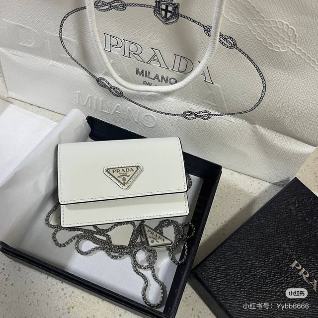 家女士多功能迷你小背包，型号1Mr034，翻盖式卡夹搭配可拆卸的Saffiano皮革肩带，金属三角形微标装点正面，尺寸11.5 X8 X2.5Cm，内设两个卡槽