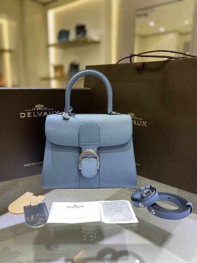 Delvau沙丘色，以RodéOcalf粒纹小牛皮打造的Brillant包袋因简洁的皮革剪裁和优美流畅的线条脱颖而出，标志性的“D”形银色饰扣象征着Delvau