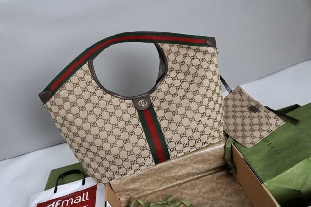厂价 。 最高版本原厂皮顶级原单配专柜全套包装 简介：帆布致敬品牌立等可辨的Gg字母交织图案，该图案源自品牌创始人先生的姓名首字母缩写。这款日常托特包缀饰红绿织