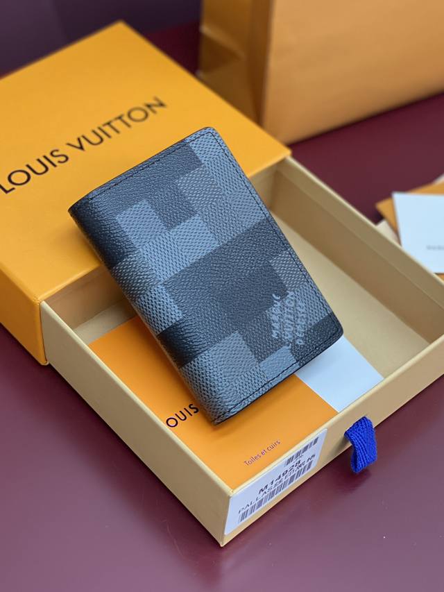 出厂价P M14928 袋裝萬用錢包！這款小巧的袋裝萬用錢包以Damoflage Black塗層帆布製造，散發別具時尚感的剛陽氣息。錢包靈感源自Damier G