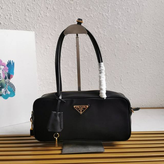 顶级原单 新款手提包1Bb133到货这款手提包造型挺括而小巧，采用再生尼龙 Re-Nylon 和皮革材质，精致优雅。饰有金属五金配件和涂珐琅三角形金属徽标，拉链