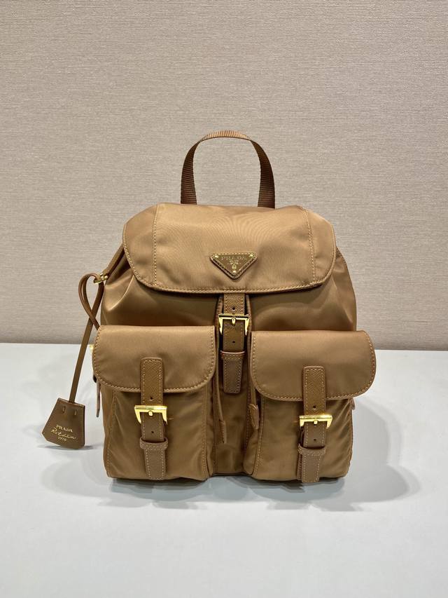 特级原厂金扣经典背包1Bz677金色五金这款实用而创新的背包采用进口尼龙面料，可调式肩带和编织提手，可拆卸Re-Edition皮革钥匙环，正面搭扣翻盖口袋，翻盖