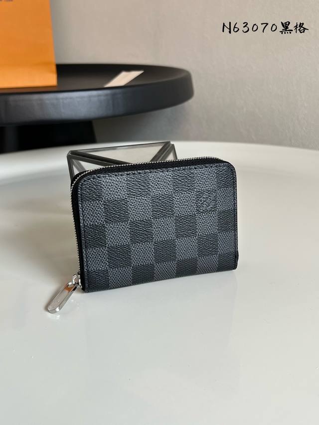 出厂价P 芯片版 N63070黑格 拉链零钱包 都市人提供了最理想的选择。包身精巧紧凑，可以用来装零钱、信用卡和折叠起来的纸币。即使身上的口袋小，也可轻松地将它