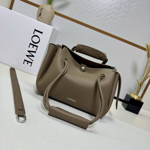 罗家新款小号柔软粒面牛皮革 Madrid 手袋Madrid 具有柔软的结构感梯形造型，采用角撑设计，搭配可调节提手和 Pebble 磁扣。此小号版本采用柔软粒面