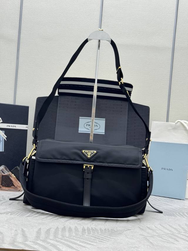 新款邮差包1Bd391大号这款手袋完美融合精致与功能性，采用再生尼龙材质，轮廓柔和，配有多个口袋。轻盈实用的设计结合运动与百搭元素，饰有涂珐琅三角形金属徽标，搭