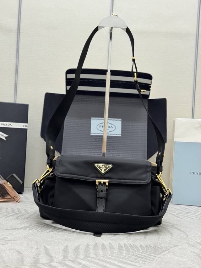 新款小号邮差包1Bd394小号这款手袋完美融合精致与功能性，采用再生尼龙材质，轮廓柔和，配有多个口袋。轻盈实用的设计结合运动与百搭元素，饰有涂珐琅三角形金属徽标