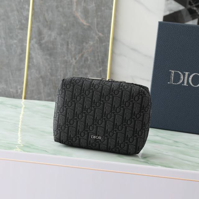 这款旅行手拿包实用又时尚。采用黑色Oblique 印花面料等材质精心制作，正面饰以Dior标志提升格调。缝有三角形衬料的设计，宽大的拉链隔层设有三个插袋和弹力带