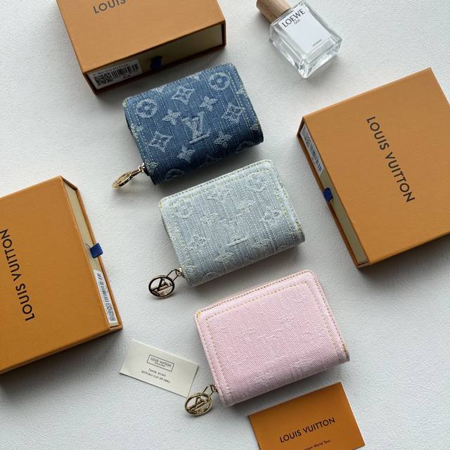 颜色 灰 粉 兰尺寸 11.5X8.5X2.2Portefeuille Roux”采用有机棉制成，并采用交织字母图案的交织字母牛仔布制成。它具有金色 Lv 圆形