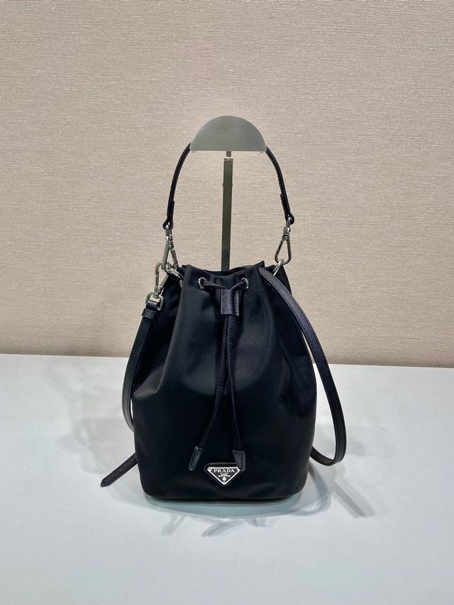 厂价 。 最高版本原厂皮顶级原单配专柜全套包装 中古水桶包1Ba038B太精致了 这款中古水桶包采用进口尼龙材质，搭配一短一长牛皮肩带，显得更加精致灵动，容量空